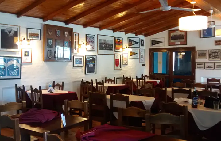 Comedor del predio con mesas tendidas y paredes con cuadros y camisetas